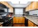 Small kitchen with wood cabinets and black appliances at 6232 Lanning Ln, Las Vegas, NV 89108