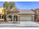 Tan two-story house with a two-car garage and landscaped yard at 6232 Novak St, Las Vegas, NV 89115