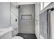 Modern shower with marble and grey tile and a black hexagon floor at 6252 Fairwood Ave, Las Vegas, NV 89107