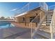 Home's outdoor living space with a pool, patio, and stairway to the upper level balcony at 6255 Adenmoor Ct, Las Vegas, NV 89156