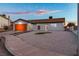 Home exterior with gravel yard, orange garage door, and landscaping at 6255 Adenmoor Ct, Las Vegas, NV 89156