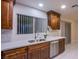 Kitchen sink and dishwasher in a modern kitchen with wood cabinets at 6584 Banbridge Dr, Las Vegas, NV 89103