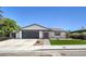 Modern house exterior with artificial turf and dark gray garage door at 7205 Carrondale Way, Las Vegas, NV 89128