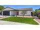 Modern house exterior with artificial turf and dark gray garage door at 7205 Carrondale Way, Las Vegas, NV 89128