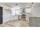 Modern kitchen with white cabinets, granite countertops, and stainless steel appliances at 7205 Carrondale Way, Las Vegas, NV 89128