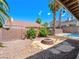 Spacious backyard with fire pit and partial pool view at 8474 Orange Cliff Ct, Las Vegas, NV 89123