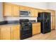 Kitchen features wood cabinets, black appliances, and black countertops at 8474 Orange Cliff Ct, Las Vegas, NV 89123