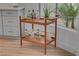 Close-up of a vintage-style bar cart with glass bottles, wooden shelves, and gold accents near the kitchen window at 8941 Diamond Falls Dr, Las Vegas, NV 89117