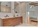 This elegant bathroom features a double vanity, modern lighting, and a serene view into the Primary bedroom at 8941 Diamond Falls Dr, Las Vegas, NV 89117