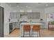 Modern kitchen features gray cabinets, marble countertops, and an island with seating at 8941 Diamond Falls Dr, Las Vegas, NV 89117