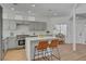 Bright kitchen featuring gray cabinets, quartz countertops, and an island with seating at 8941 Diamond Falls Dr, Las Vegas, NV 89117