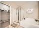 Bathroom featuring a soaking tub and separate glass-enclosed shower and walk in closet at 904 Domnus Ln # 201, Las Vegas, NV 89144