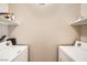 Bright laundry room with washer, dryer, and shelving for ample storage at 904 Domnus Ln # 201, Las Vegas, NV 89144