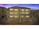 Upscale condo building exterior at dusk, featuring multiple levels and balconies at 9201 Las Manaitas Ave # 302, Las Vegas, NV 89144