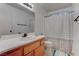 Bathroom featuring a wooden vanity, toilet, and shower with a white and gray patterned curtain at 9290 Cool Creek Ave, Las Vegas, NV 89147