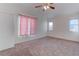 A neutral bedroom has pink curtains and a ceiling fan at 9290 Cool Creek Ave, Las Vegas, NV 89147