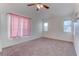 A neutral bedroom has pink curtains and a ceiling fan at 9290 Cool Creek Ave, Las Vegas, NV 89147