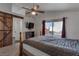 Spacious bedroom with wooden bed frame, barn door, and balcony access at 9290 Cool Creek Ave, Las Vegas, NV 89147