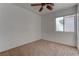 Bedroom with neutral carpet, a ceiling fan, and a window providing natural light at 9290 Cool Creek Ave, Las Vegas, NV 89147