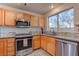 Modern kitchen with stainless steel appliances and wood cabinets at 9290 Cool Creek Ave, Las Vegas, NV 89147