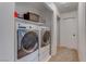 Bright laundry room with washer, dryer, and shelving at 9290 Cool Creek Ave, Las Vegas, NV 89147