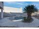 Backyard pool surrounded by desert landscaping, including a palm tree and rock waterfall feature at 9290 Cool Creek Ave, Las Vegas, NV 89147