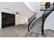 Modern curved staircase with black railing and gray wood steps at 9541 Summersweet Ct, Las Vegas, NV 89123