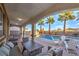 Inviting covered patio area with comfortable seating, ping pong table, and views of the sparkling pool and swaying palm trees at 12259 Pacific Cruise Ave, Las Vegas, NV 89138