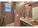 Cozy powder room features a vanity, decorative mirror, and warm earth tones at 12259 Pacific Cruise Ave, Las Vegas, NV 89138