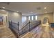 Second story hallway overlooking staircase with hardwood floors and three windows at 12259 Pacific Cruise Ave, Las Vegas, NV 89138