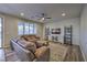 Comfortable living room with a large sectional sofa, ceiling fan, and modern decor at 12259 Pacific Cruise Ave, Las Vegas, NV 89138