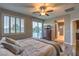 Comfortable main bedroom featuring a ceiling fan, balcony access, and ensuite bathroom at 12259 Pacific Cruise Ave, Las Vegas, NV 89138