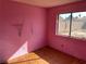 Small bedroom with pink walls and wood-look flooring at 1275 White Dr, Las Vegas, NV 89119