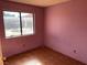 Small bedroom with pink walls and wood-look flooring at 1275 White Dr, Las Vegas, NV 89119