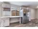 Bright kitchen featuring stainless steel refrigerator, white cabinetry, and a functional built-in desk area at 1309 Jimmy Ave, Las Vegas, NV 89106