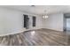 Open living room featuring gray-toned flooring, neutral wall paint, stylish light fixture, and glass patio doors at 1309 Jimmy Ave, Las Vegas, NV 89106