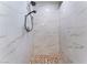 Walk-in shower with white marble-look tile walls, a rainfall shower head and a pebble floor at 1309 Jimmy Ave, Las Vegas, NV 89106