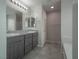 Double sink bathroom with granite countertops, gray cabinets, and tile floors at 2240 Sky Island Dr, Henderson, NV 89002