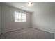 A sunlit bedroom features neutral carpeting, light gray walls, and a window with blinds at 2240 Sky Island Dr, Henderson, NV 89002