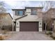 Beige two-story home featuring a brown two-car garage and a brick driveway at 2240 Sky Island Dr, Henderson, NV 89002