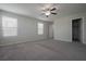 Bright main bedroom with two windows, plush carpeting, and access to the walk-in closet at 2240 Sky Island Dr, Henderson, NV 89002