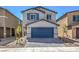 Two-story home with gray siding, blue garage door, and landscaping at 2633 Snapdragon Falls Ave, North Las Vegas, NV 89081