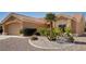 Tan one-story house with tile roof, desert landscaping, and two-car garage at 3021 Isaac River Dr, Las Vegas, NV 89134