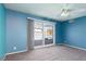 Bright bedroom with blue walls, gray carpet, and sliding glass doors leading to a patio at 3126 Cabachon Ave, Las Vegas, NV 89121