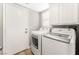 Laundry room with white washer and dryer and upper cabinets at 3728 Shimmering Creek Ave, North Las Vegas, NV 89031