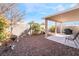 Landscaped backyard with covered patio and seating at 3952 Moon Tango St, Las Vegas, NV 89129