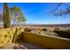 Outdoor patio showcasing lush landscaping, including a stone wall and distant mountain views, ideal for serene outdoor living at 4 Via Centrale # 3, Henderson, NV 89011