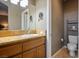 Well-lit bathroom featuring a vanity with granite countertop and a large mirror, offering a clean and functional space at 4 Via Centrale # 3, Henderson, NV 89011