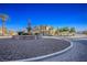 View of the home featuring desert landscaping, blue skies, and a serene fountain in the roundabout at 4 Via Centrale # 3, Henderson, NV 89011