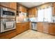 Kitchen featuring wood cabinetry, stainless steel appliances, tile backsplash, and natural lighting at 4 Via Centrale # 3, Henderson, NV 89011